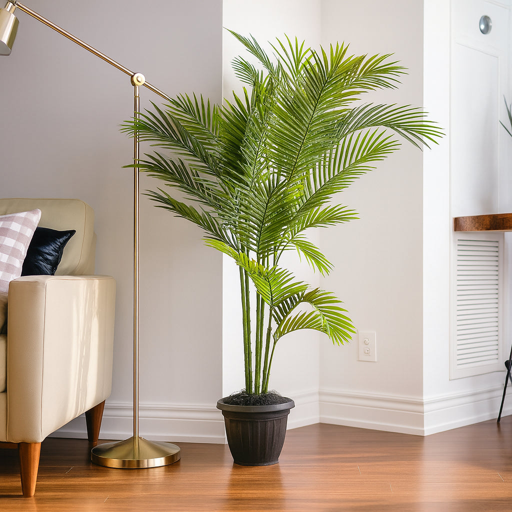 Potted palm plant in a living room with a beige armchair and gold floor lamp.